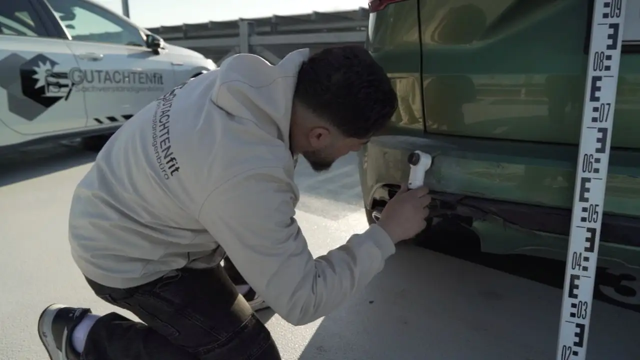 Halis Kaya prüft den beschädigten Stoßfänger mit einer Lupe