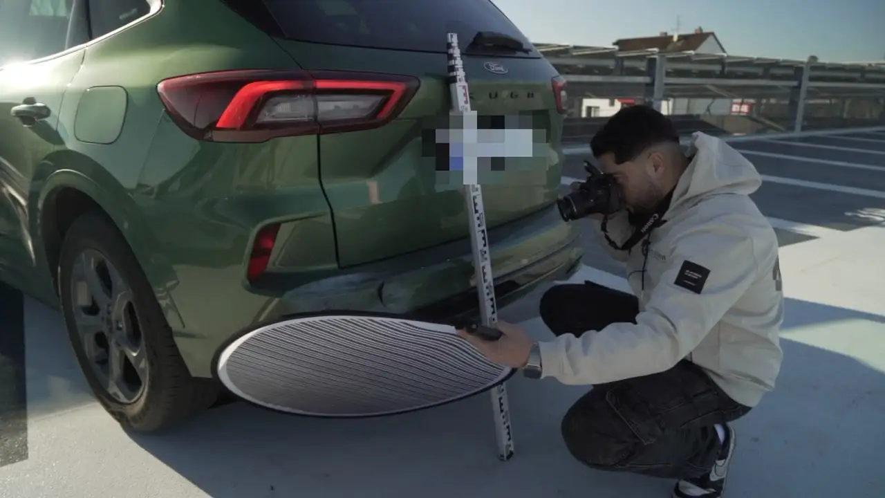 Halis Kaya fotografiert den beschädigten Stoßfänger, davor Streifenreflektor und Messlatte